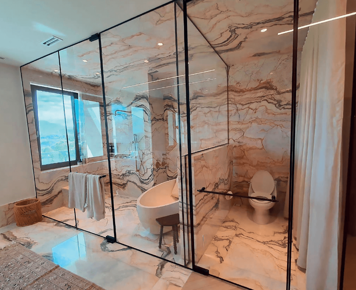 CASMA hydraulic hinges on luxury bathroom frameless glass door with black frame showing premium residential installation with marble walls